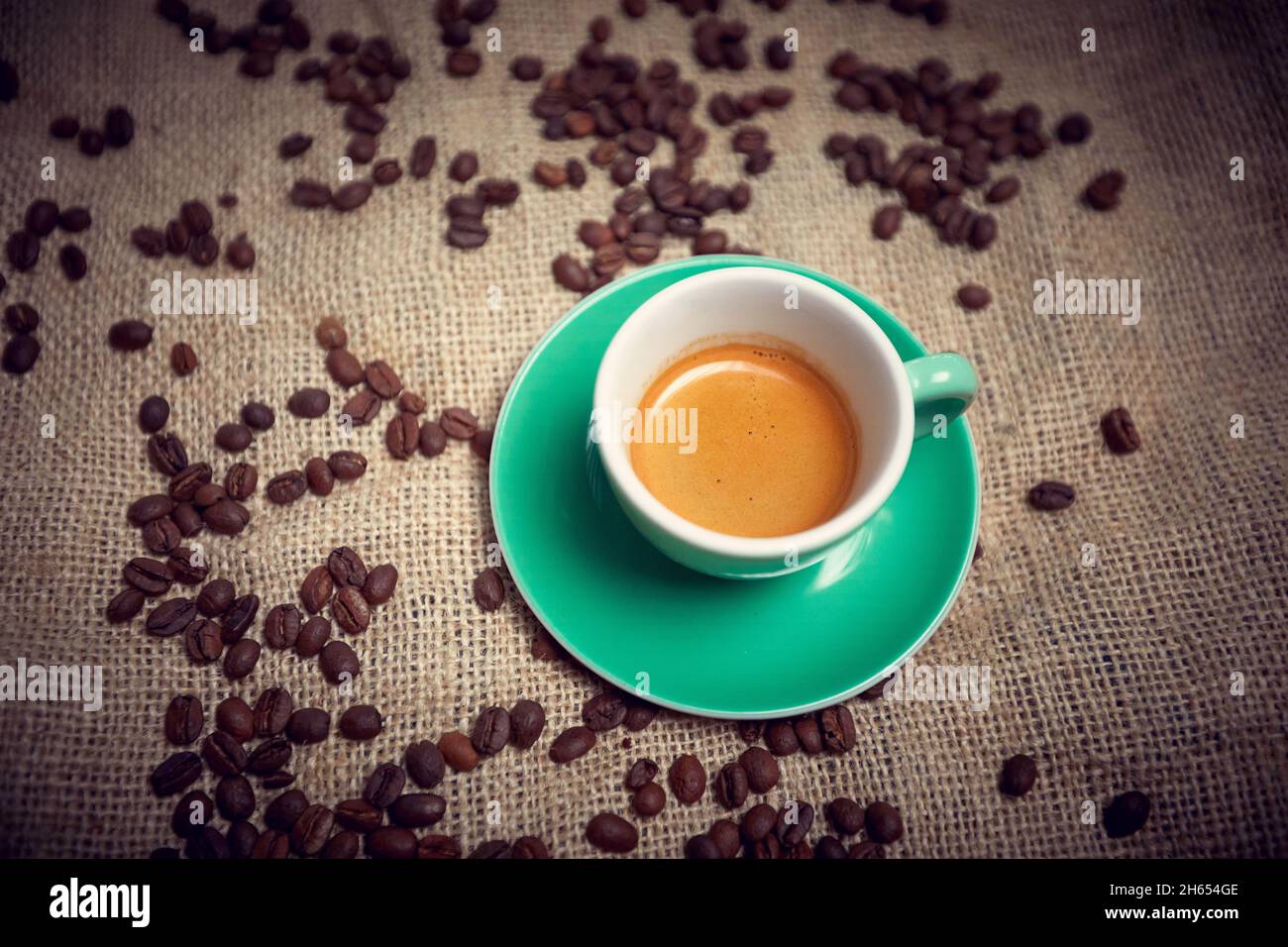 Close-up of aromatic and fragrant espresso coffee in a cup standing on a bag with coffee beans. Coffee, beverage Stock Photo