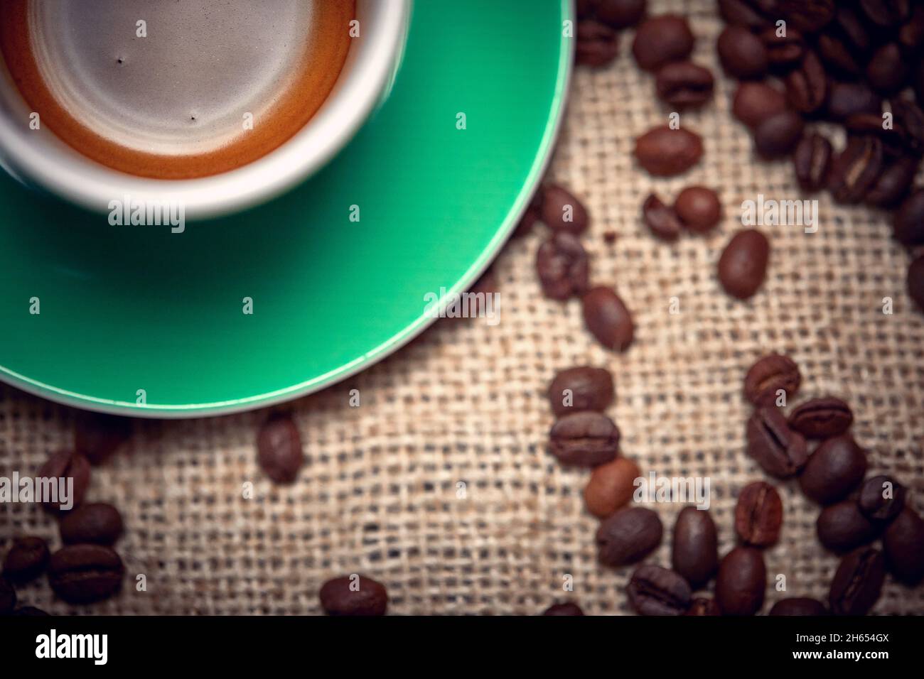 Close-up of cup of aromatic and fragrant coffee and coffee beans nicely spread over the bag. Coffee, beverage Stock Photo