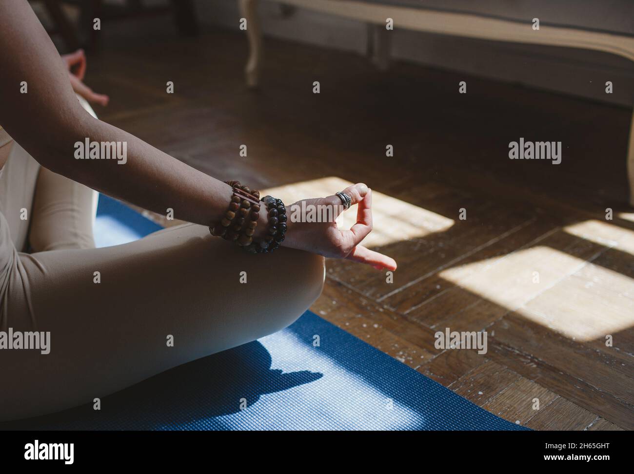 A beautiful girl is sitting on a yoga mat in the lotus position in the ...