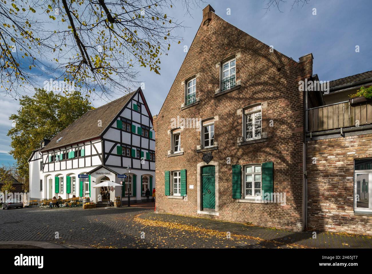 Germany, Monheim am Rhein, Rhine, Bergisches Land, Niederbergisches Land, Niederberg, Rhineland, North Rhine-Westphalia, NRW, Old City Hall in the historic downtown, former guest-house, brick building, left restaurant Tante Tina, half-timbered house with green shutters, trees with autumnal colouring Stock Photo