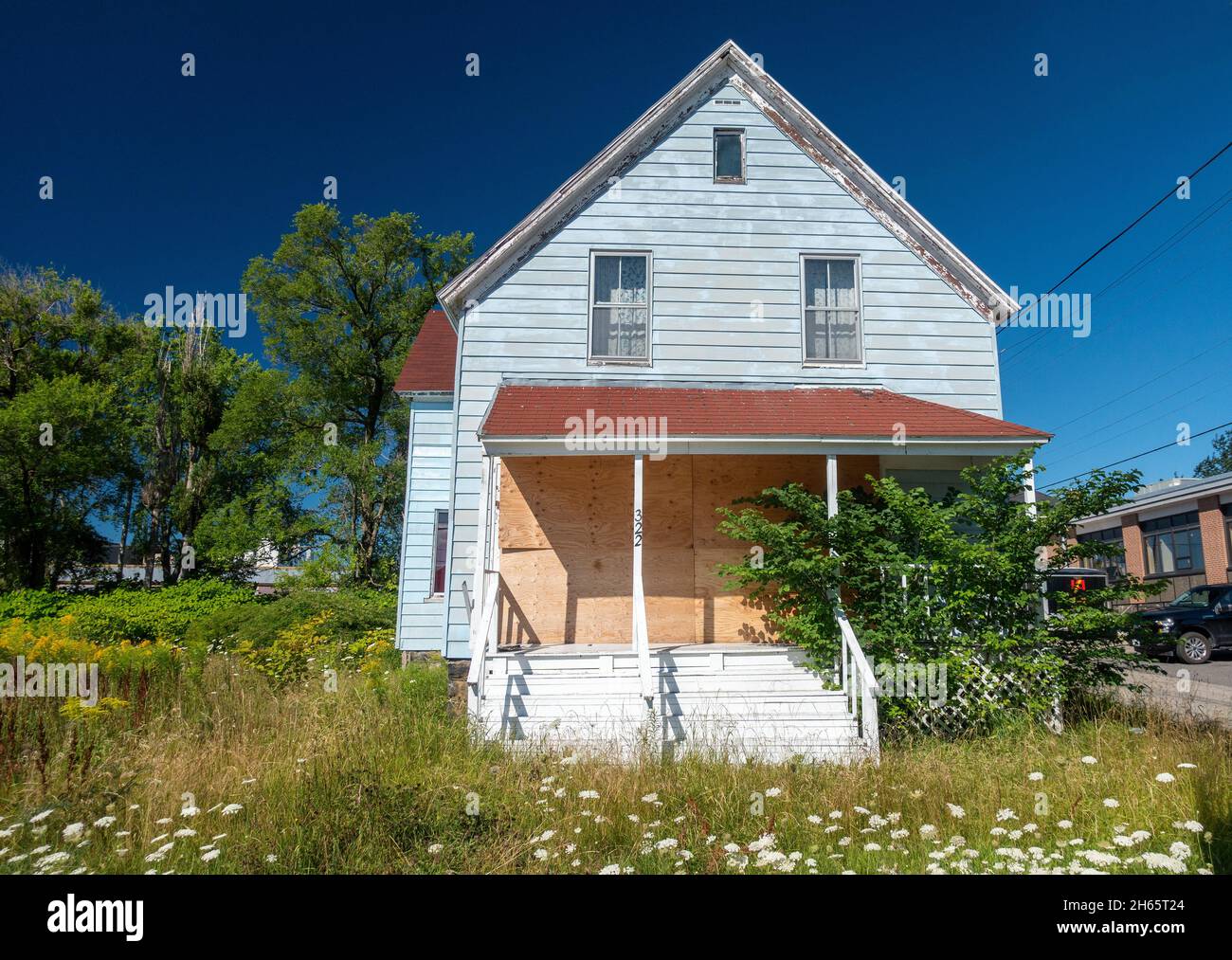 Boarded Up Abandoned House In Sydney Cape Breton Island Nova Scotia Canada, Traditional Older Home Over Grown Garden Stock Photo