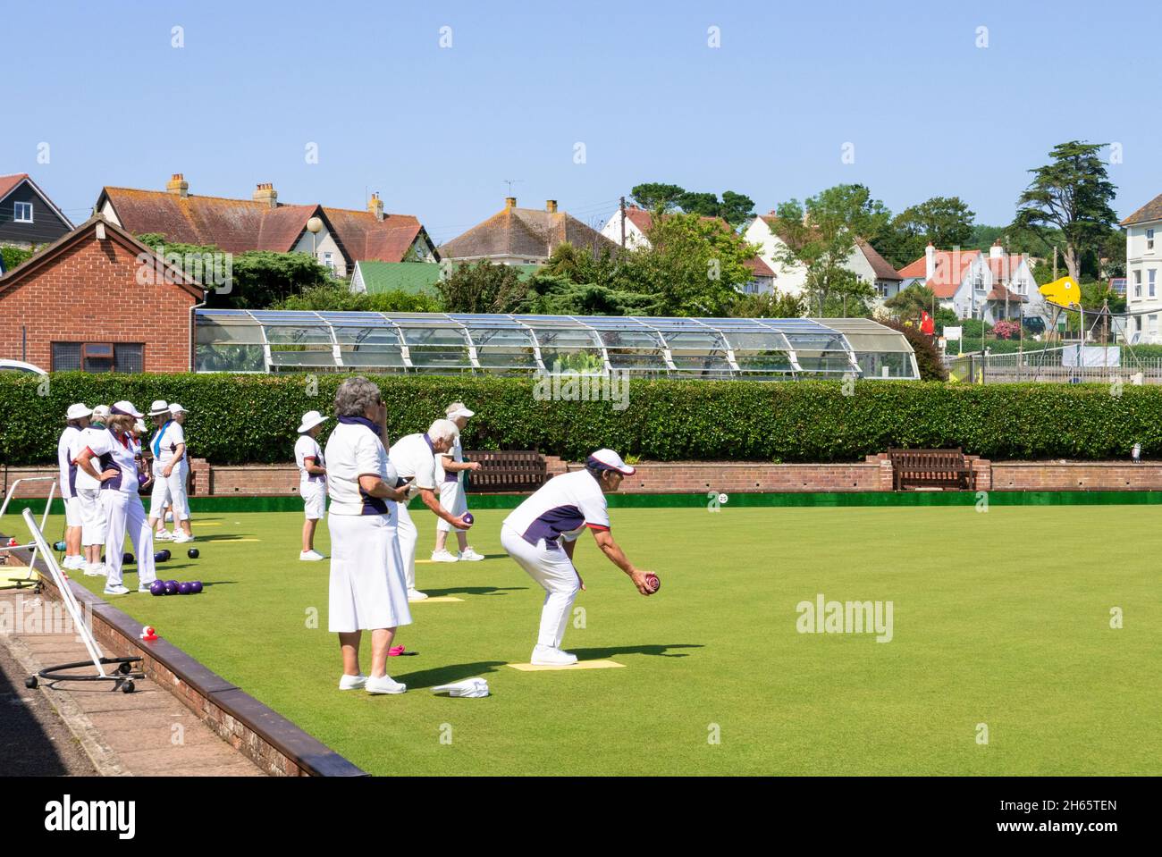 Outdoor bowling green with 2 teams playing a match or playing bowls lawn bowls Seaton Devon England UK GB Europe Stock Photo