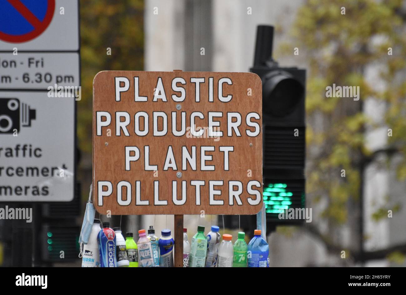 A protest sign the reads “Plastic Producers Planet Polluters” being held by a protester against single use plastic and it’s environmental impact Stock Photo