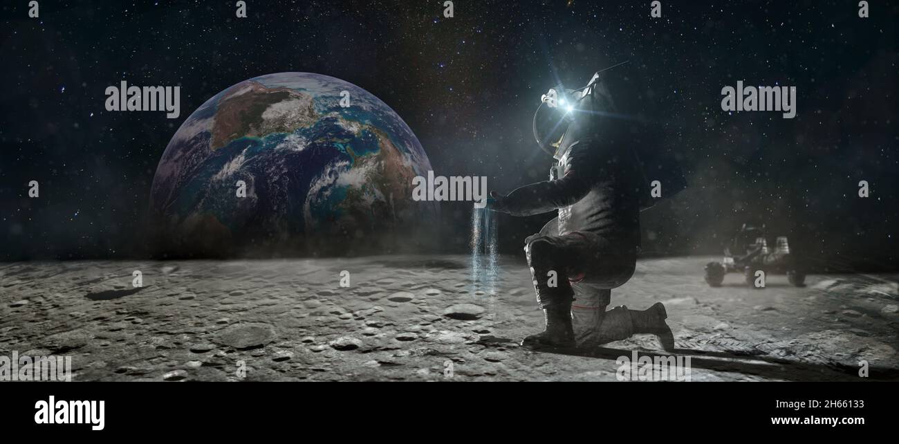 Astronaut sits on his knee on the lunar surface and pours blue earth's soil through his fingers. Planet Earth rise at the horizon. Elements of this im Stock Photo