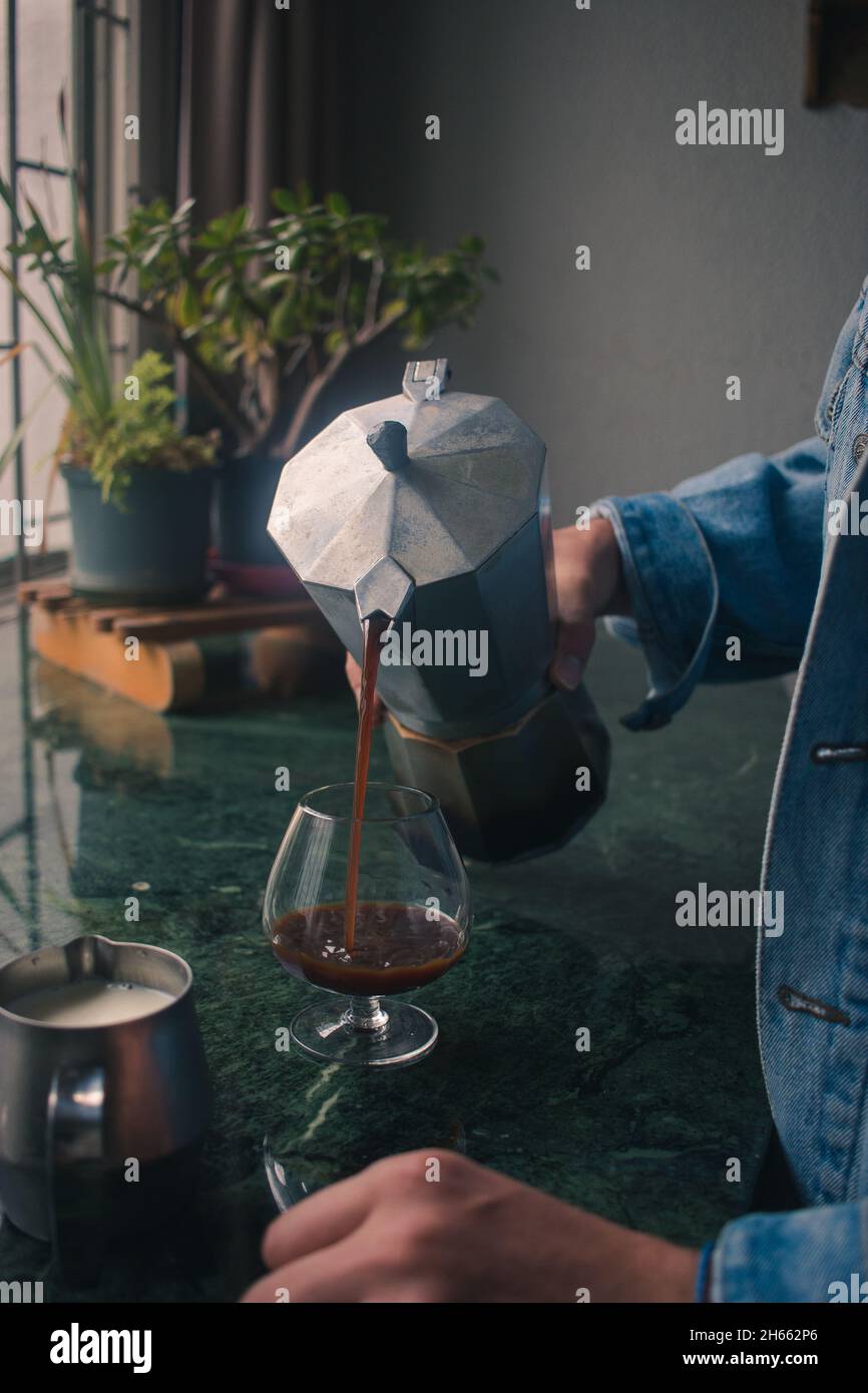 Fashionable young man pouring espresso from italian espresso maker Stock Photo