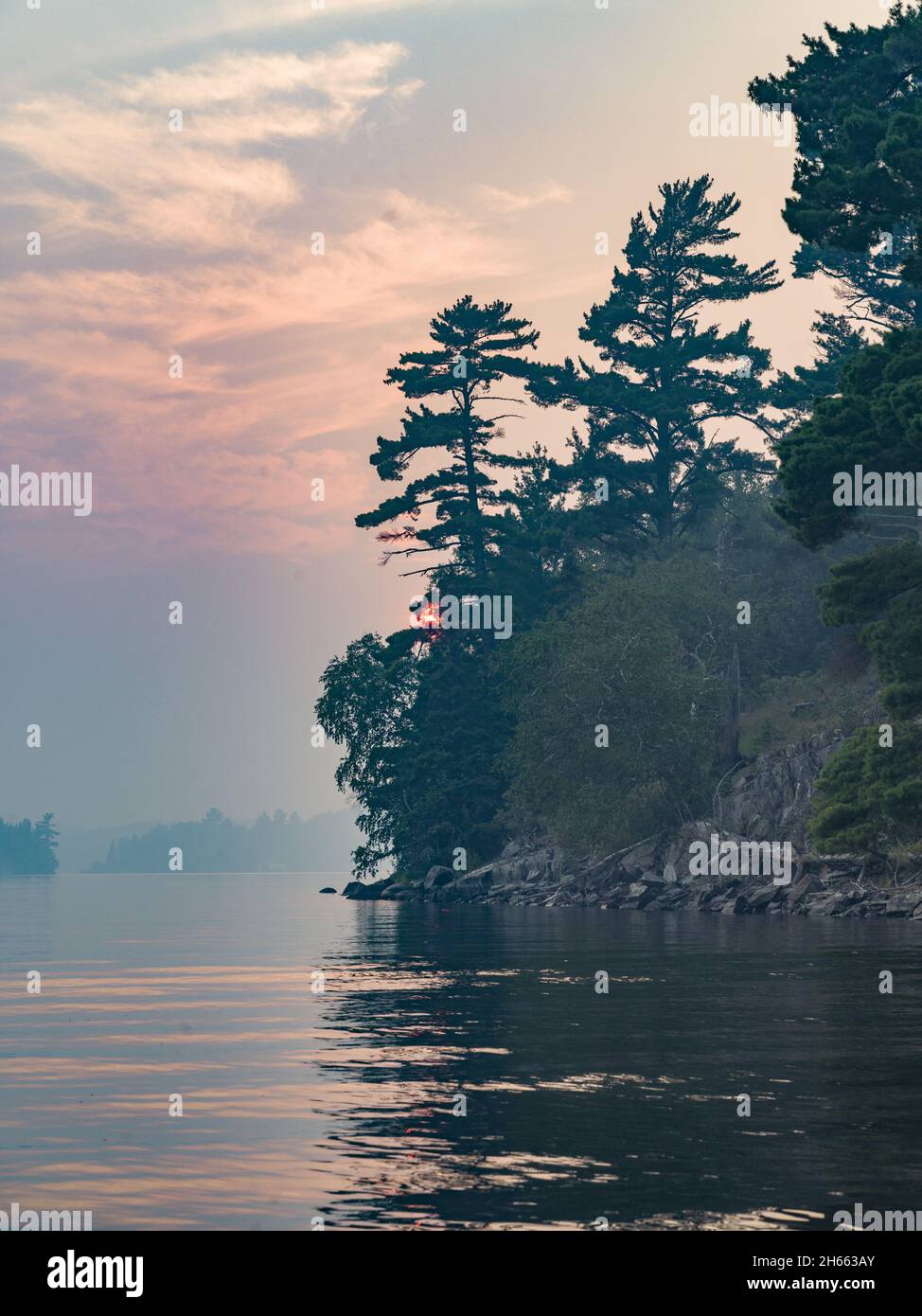 Beautiful view of a lake, pine trees on the sunset sky background Stock ...
