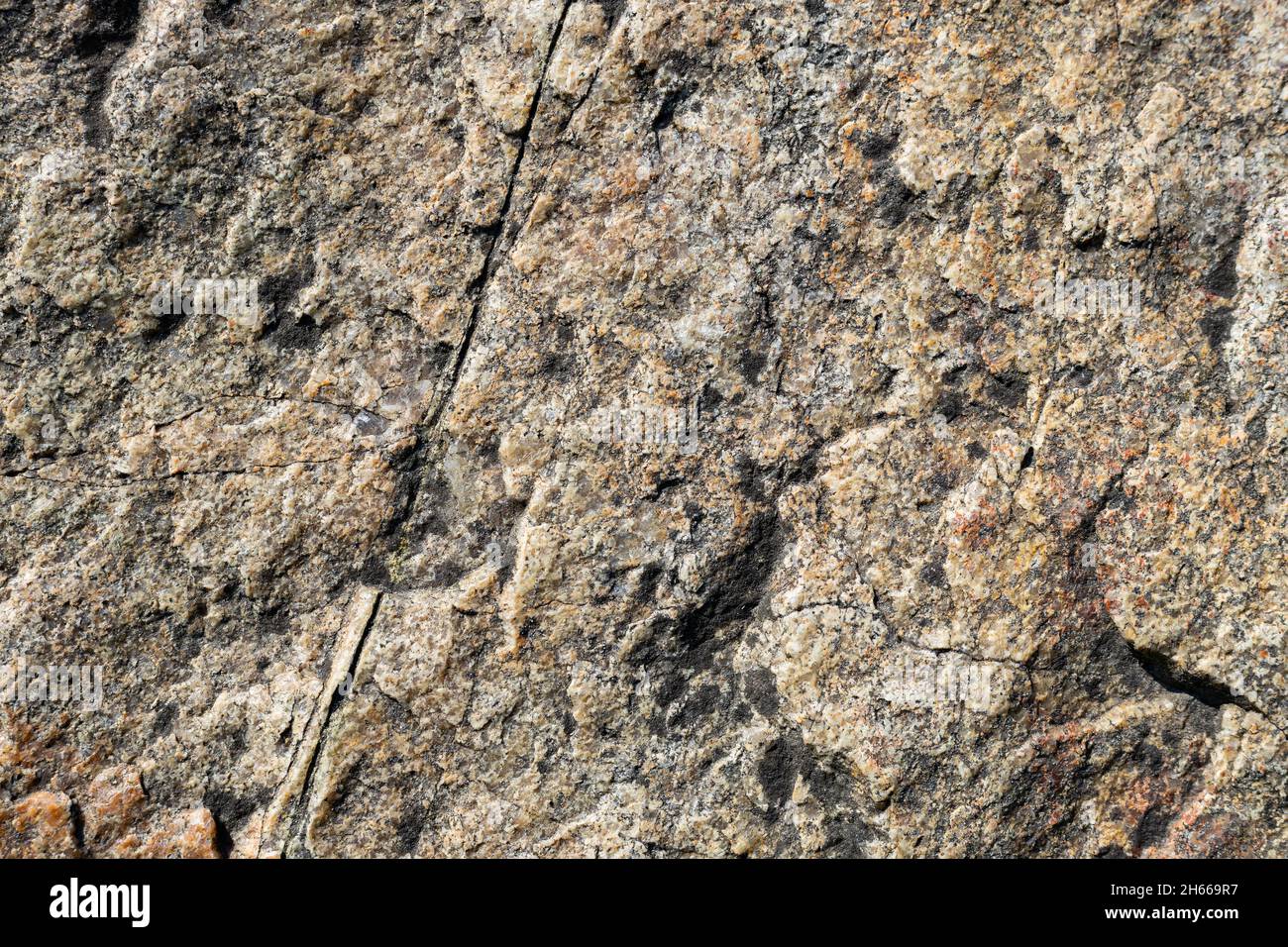 Granite rock texture. Cracked granite surface from weathering. Closeup