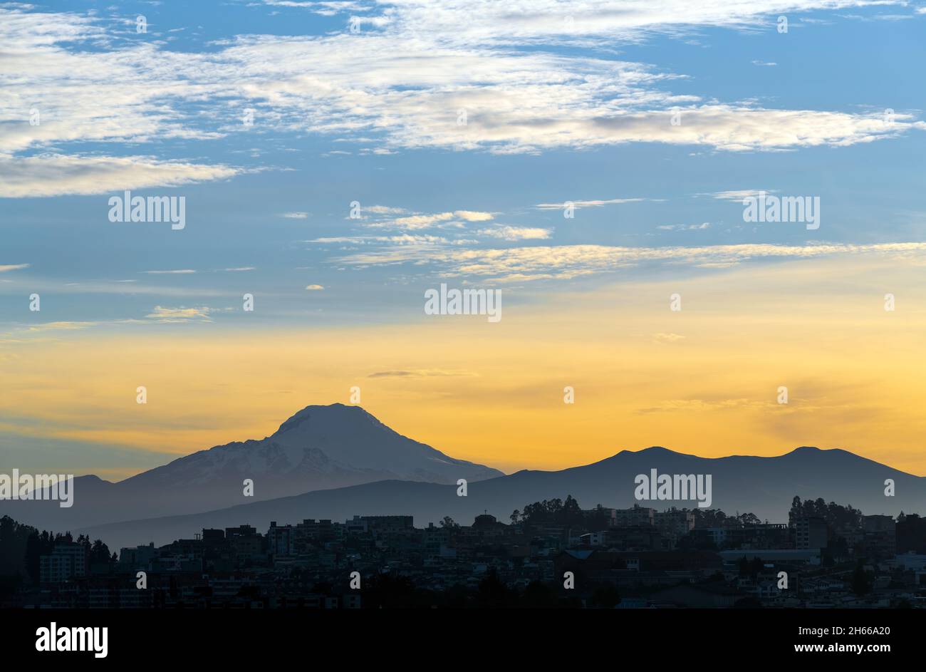 Cayambe volcano at sunrise with Quito city silhouette, Ecuador. Stock Photo