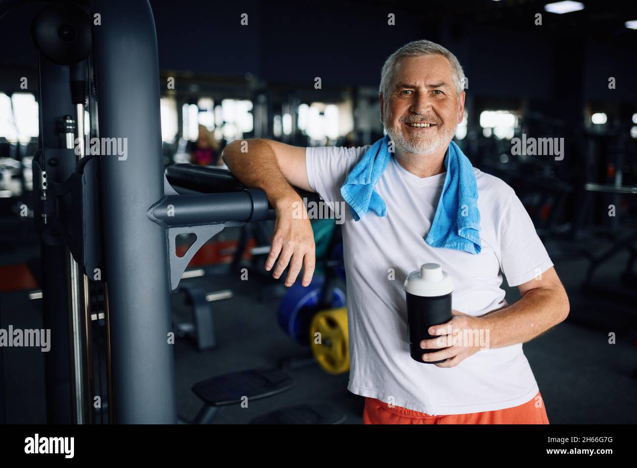 Old man with bottle of water and towel in gym Stock Photo - Alamy