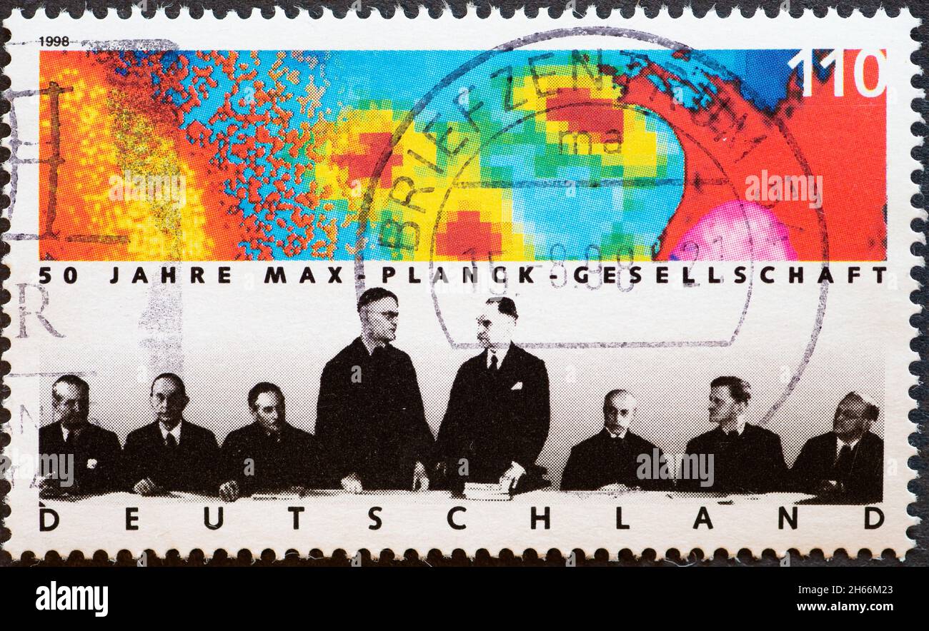 GERMANY - CIRCA 1998 : a postage stamp from Germany, showing a conference committee with graphics on the wall for the 50th anniversary of the Max Plan Stock Photo