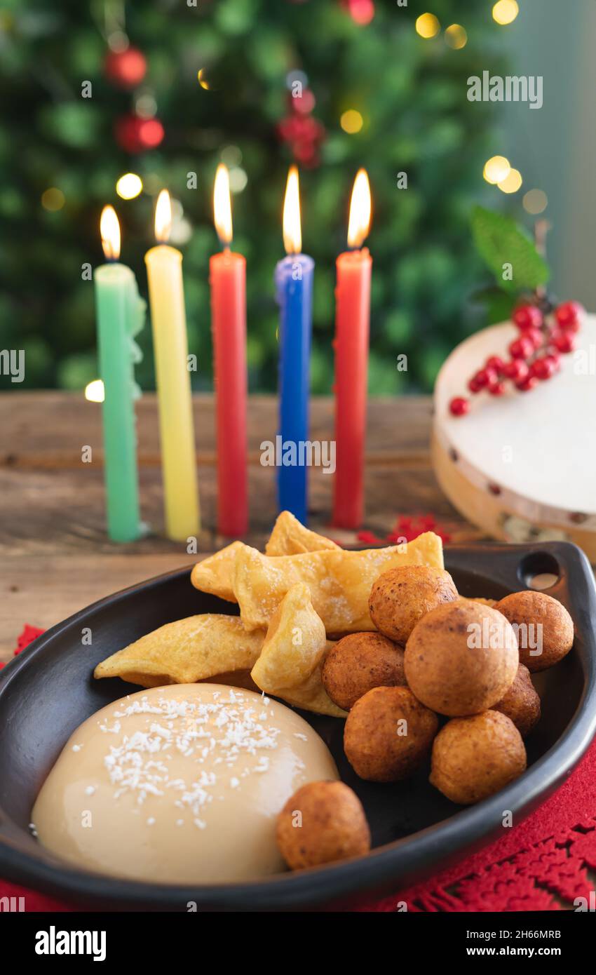 Candlelight Day. Typical Colombian food. Buñuelo, custard and flakes with candles and Christmas