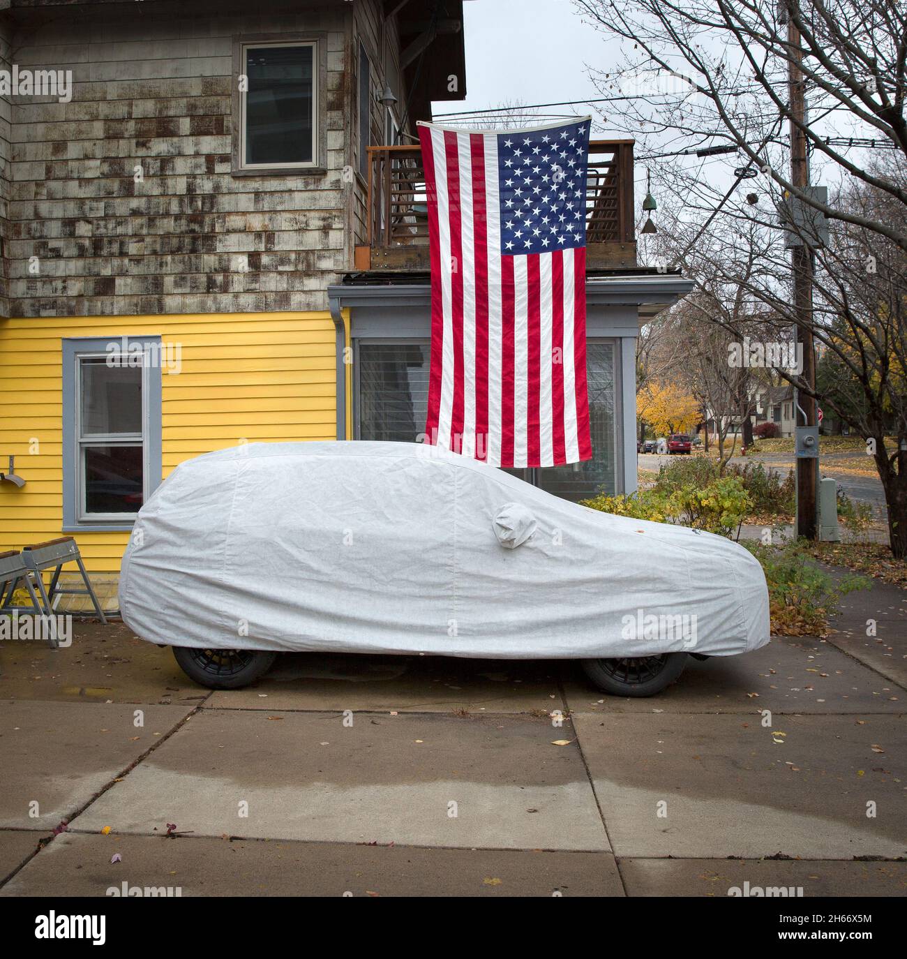 American Veteran's Day and federal holiday display of a large United States flag over a car with a protective cover. Veterans day, Armistice Day is th Stock Photo