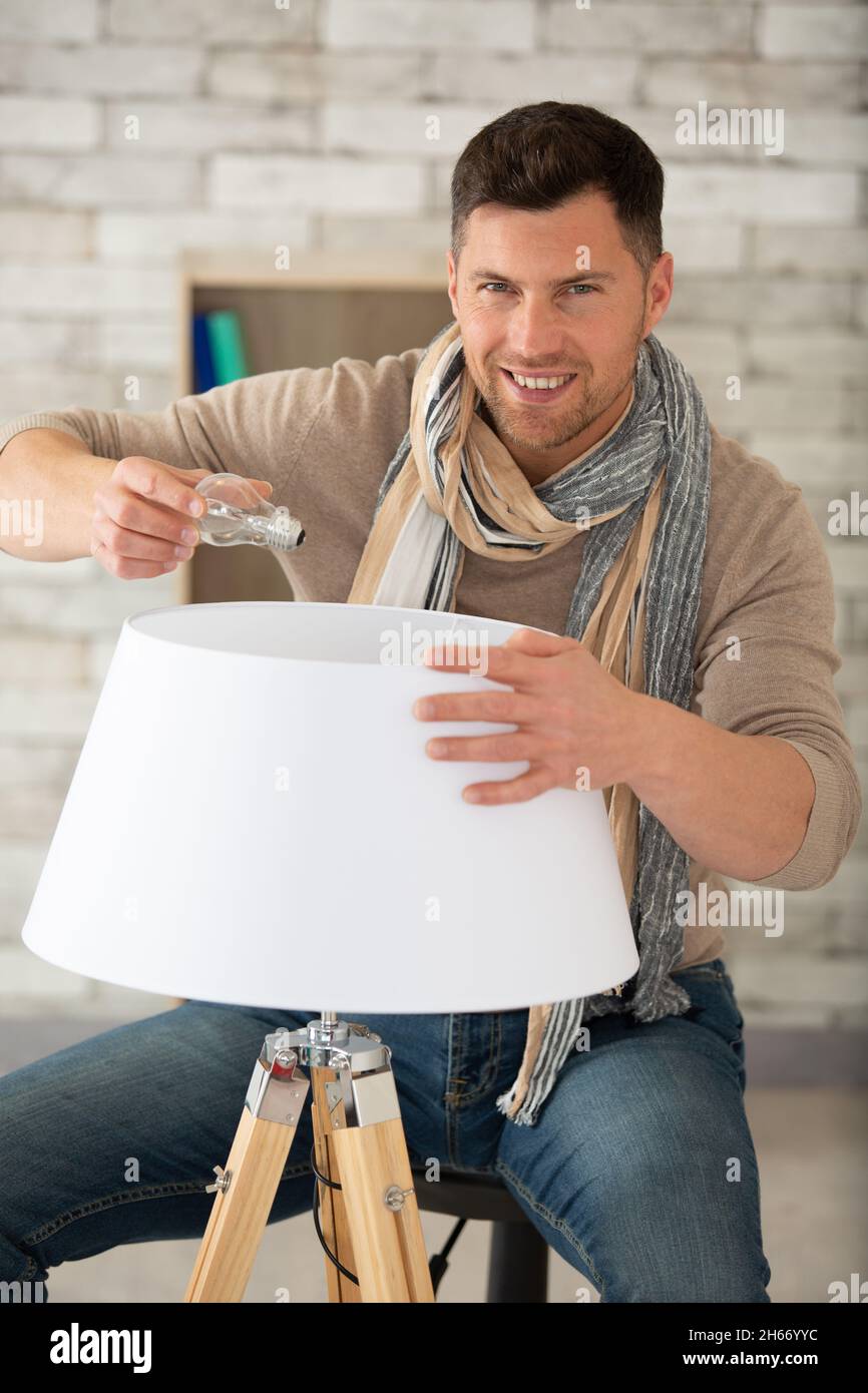 man replacing the bulb in a lamp Stock Photo