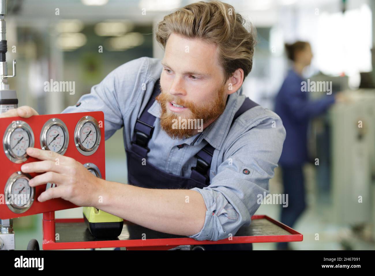 inspector checking pressure gauges on heating boiler system Stock Photo