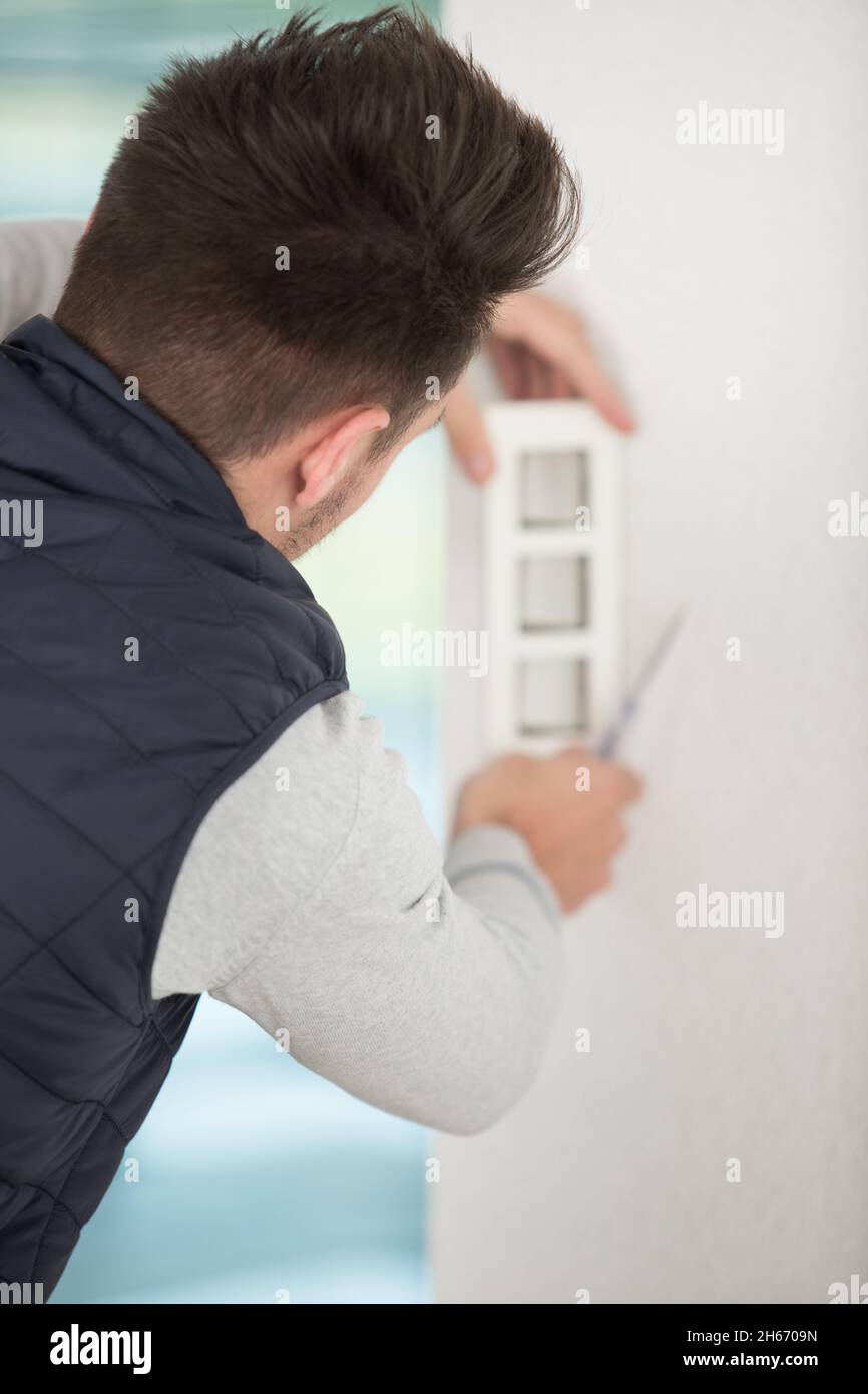 man is installing the wall bathroom fan vent Stock Photo