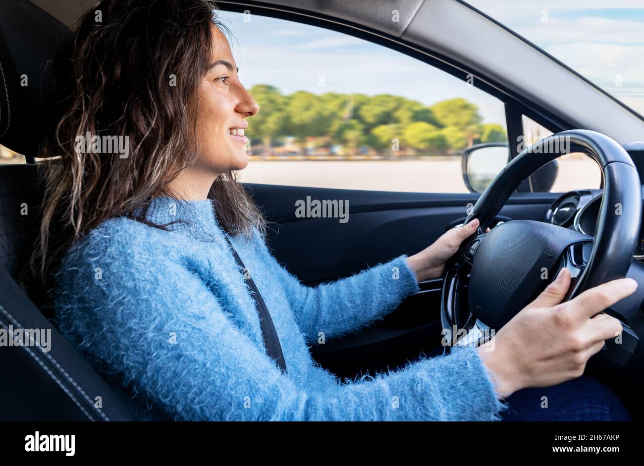Young woman driving car on the road. Driver licence and driving safety concept. Stock Photo