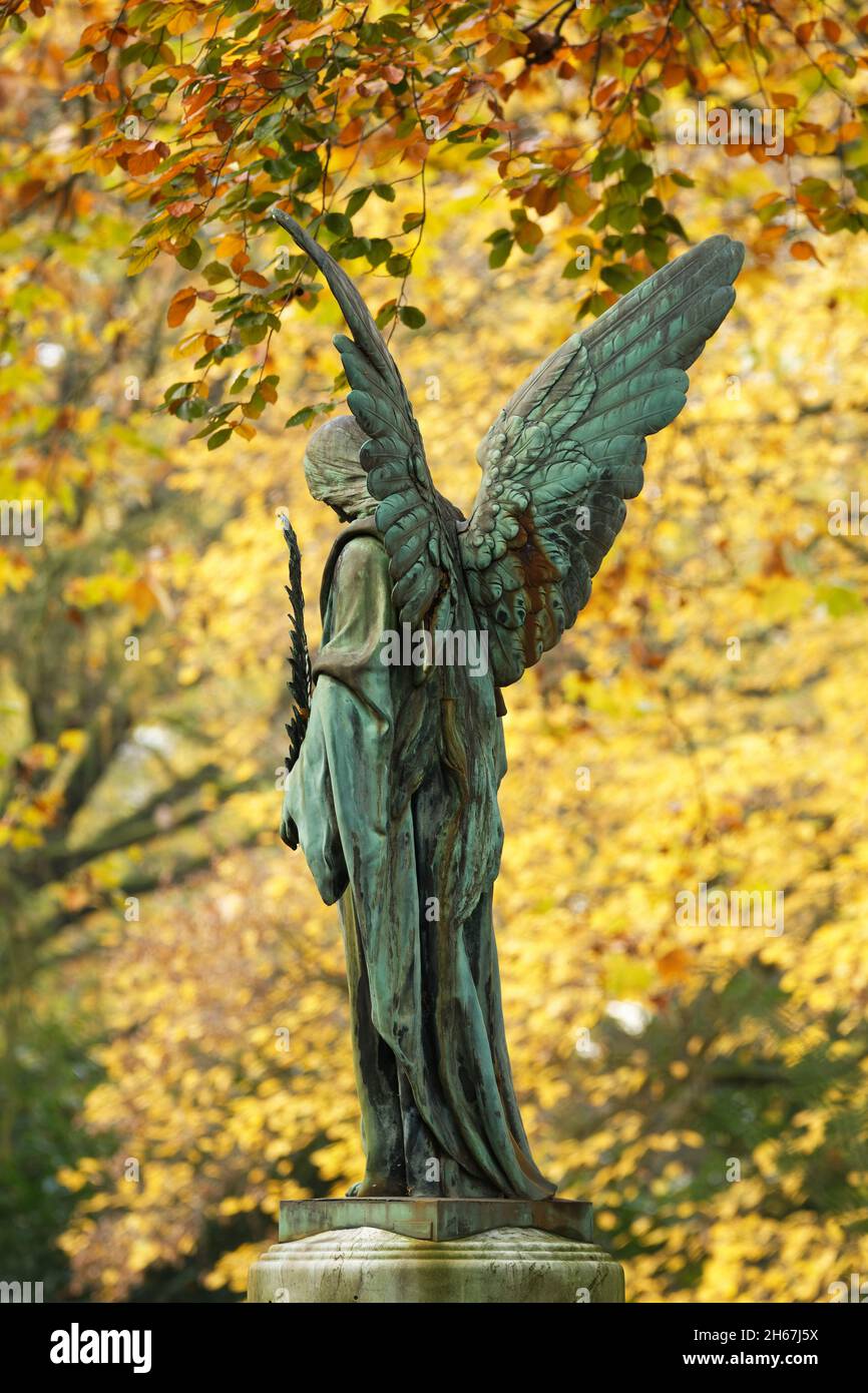 angel figure with spread wings in an autumn cemetery Stock Photo