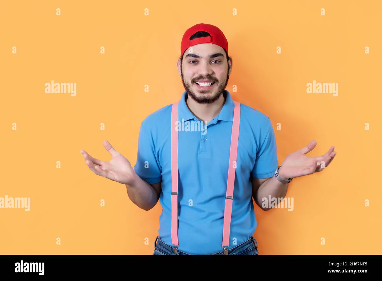 Happy man with a beard shrugging with opened arms over an orange ...