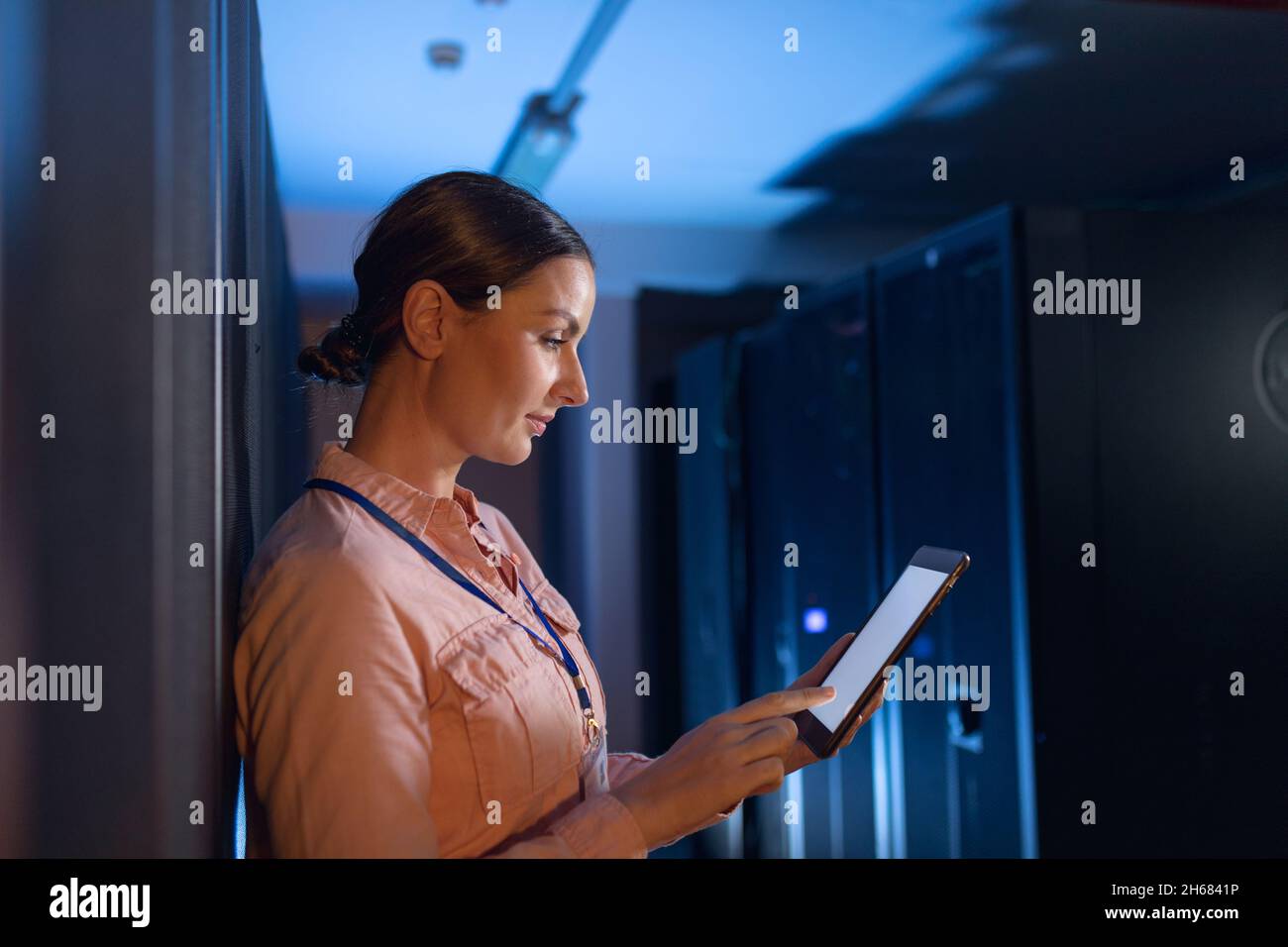 Caucasian female engineer using digital tablet in computer server room Stock Photo