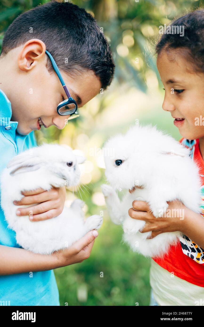 Istanbul, Turkey - 30.05.17: Little boy and girl holding white rabbits in their hands Stock Photo