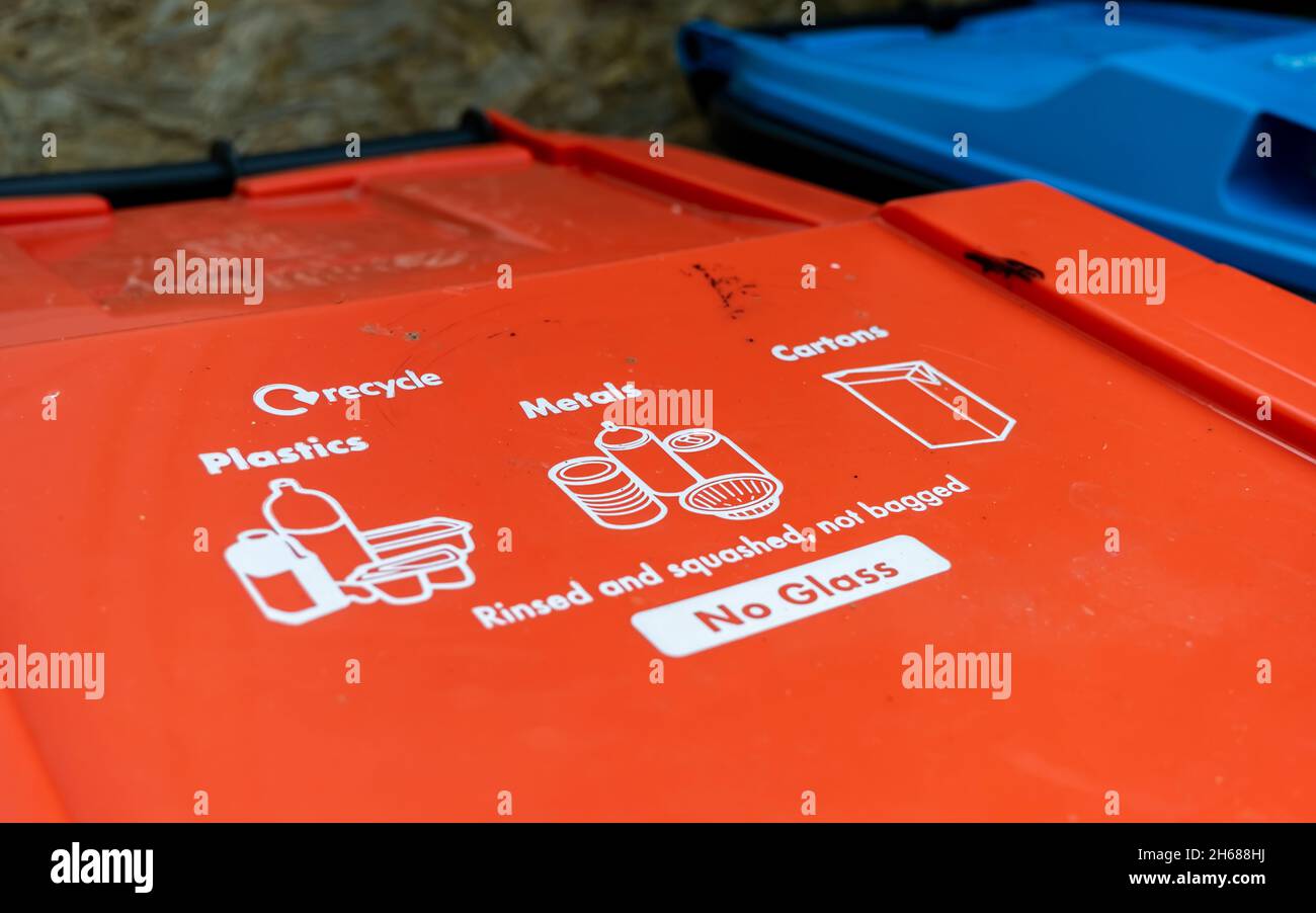 A red plastic and metal recycling trash can with instructions written on the lid Stock Photo Alamy