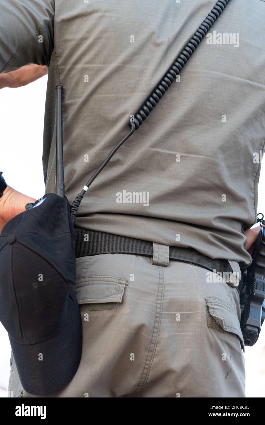 Back view of alerted undercover cop or security agent reaching hand gun attached on belt. Full body length portrait isolated on white studio background. . High quality photo Stock Photo