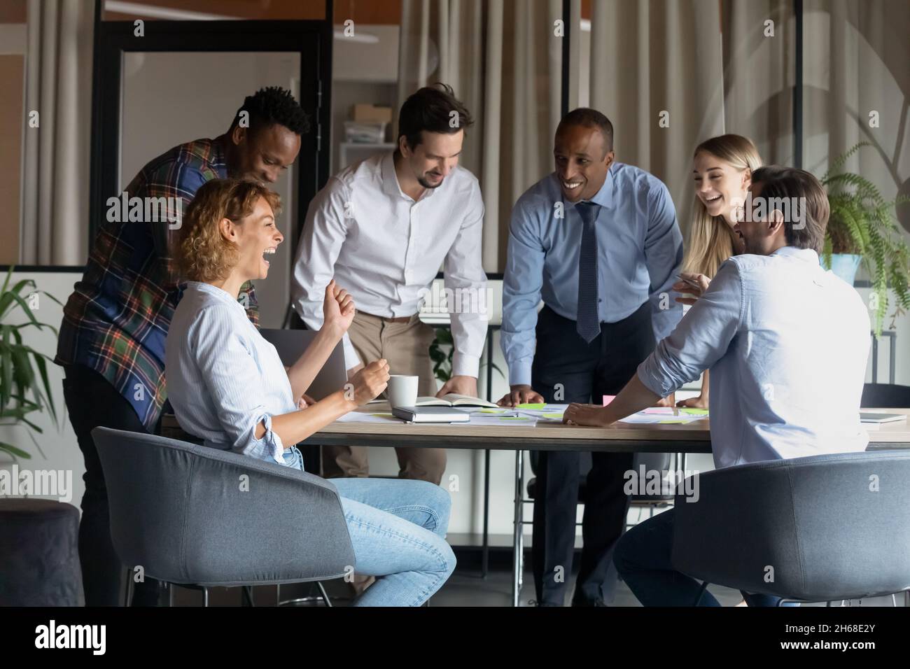 Friendly mixed race employees enjoying brainstorming activity in office. Stock Photo