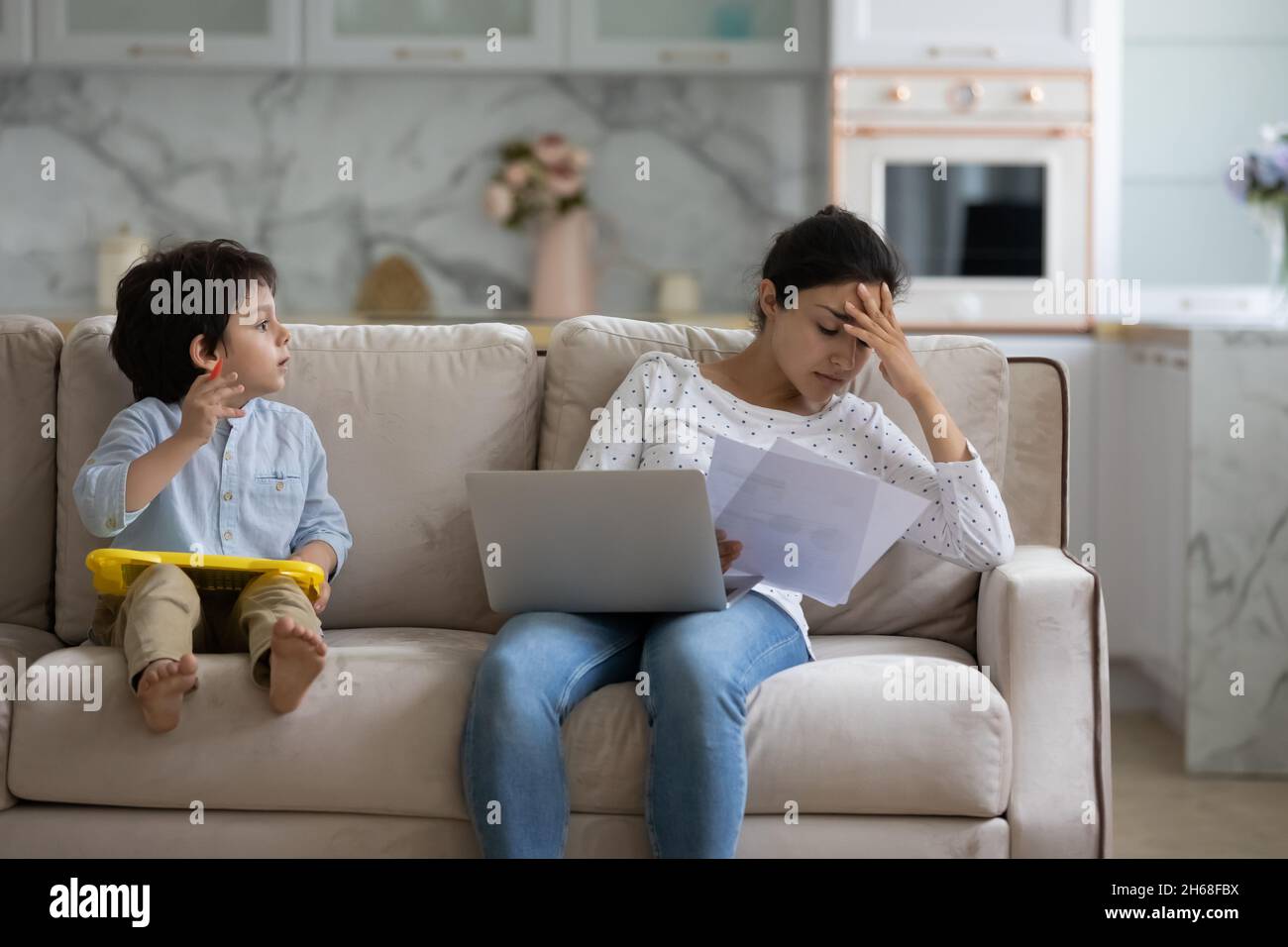 Tired young Indian freelance mom working from home Stock Photo