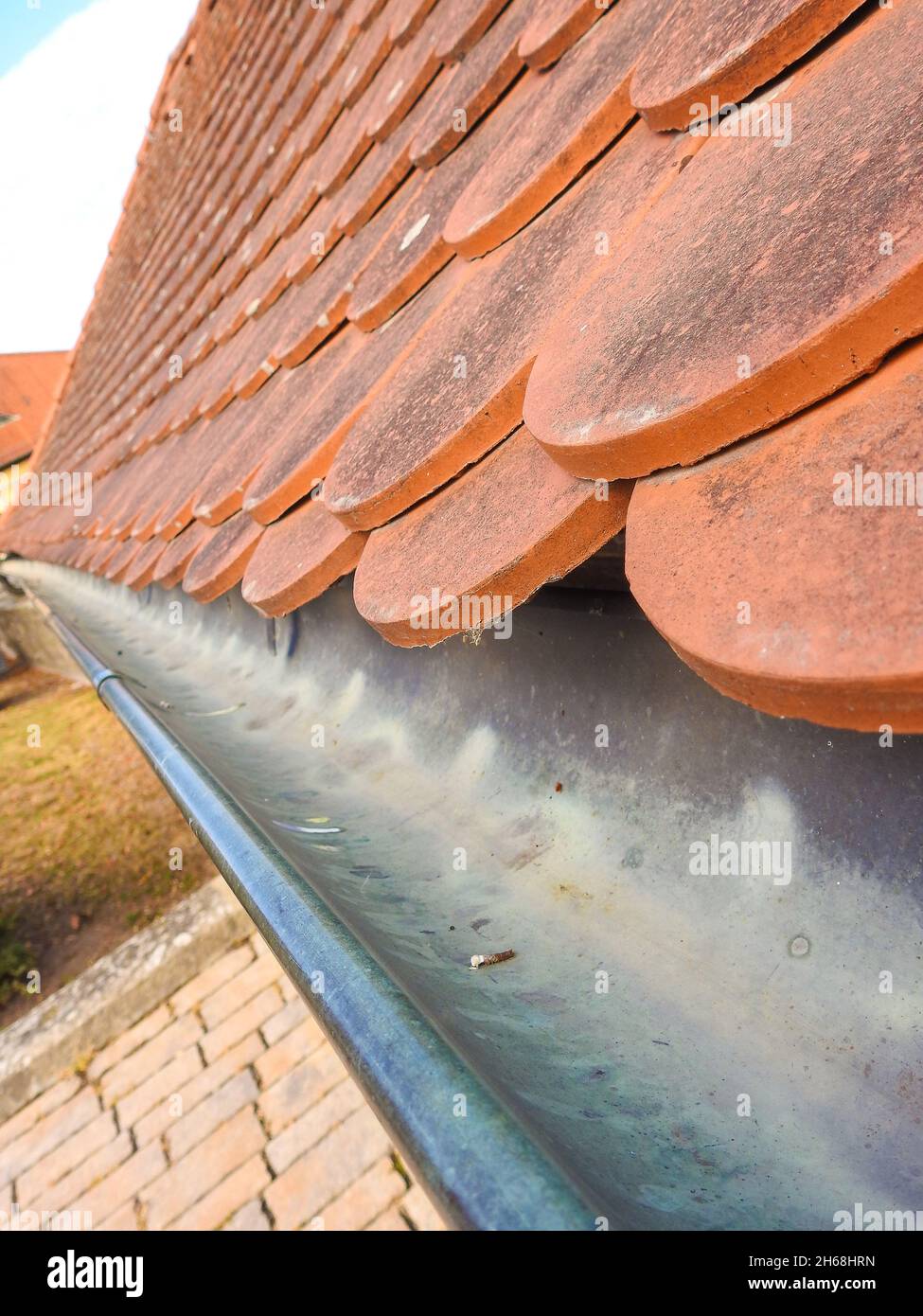 A vertical shot of roof tiles with gutter Stock Photo