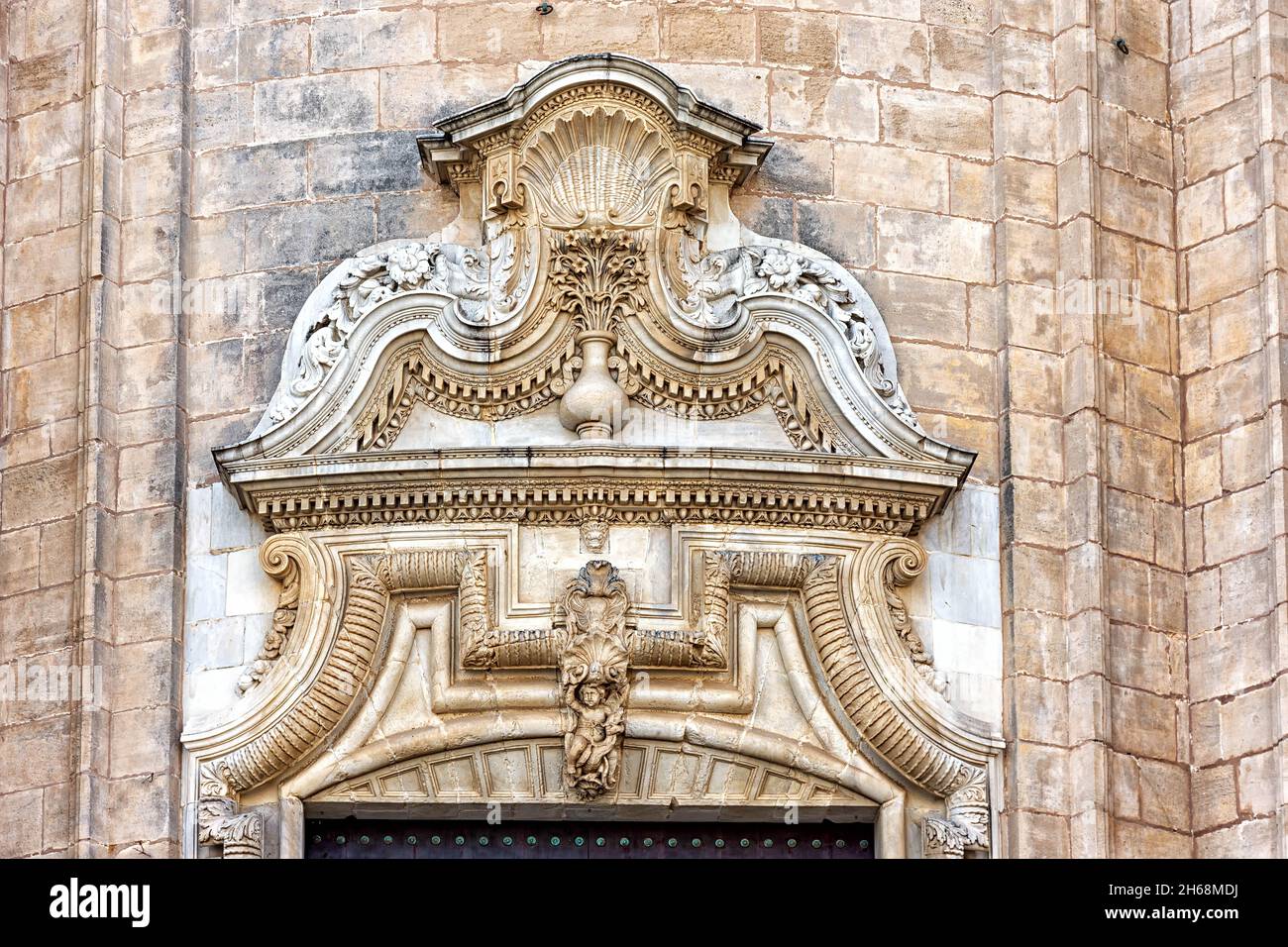 Detalle puerta en la fachada principal de la Catedral de la Santa Cruz sobre el mar en Cádiz, España Stock Photo