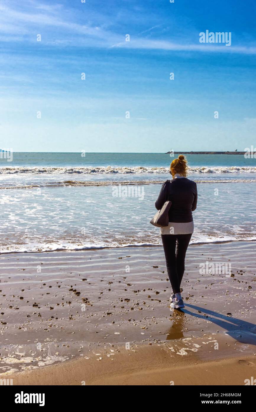 woman walking on the beach in El Puerto de Santa Maria, Cadiz Stock Photo