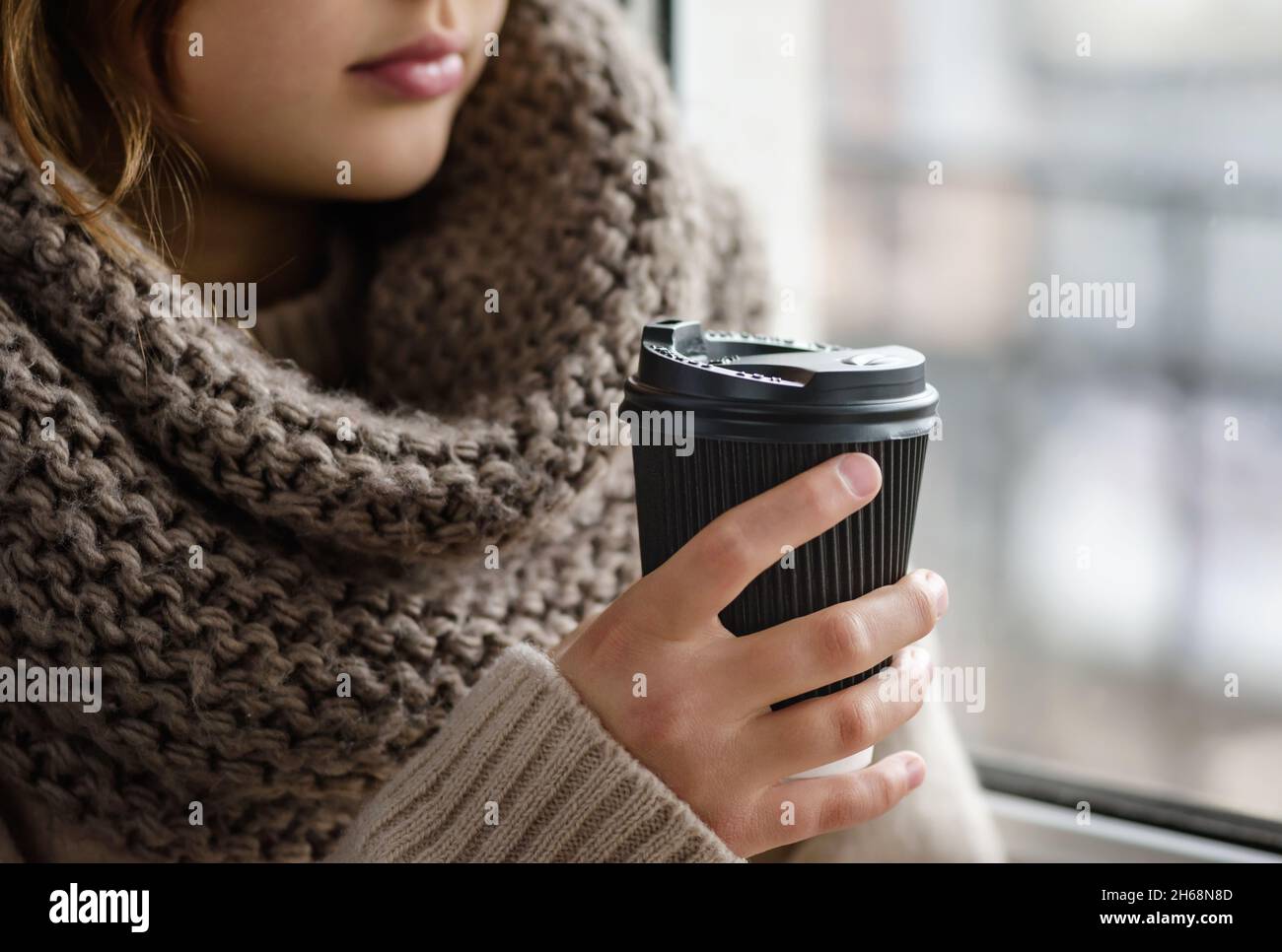 Girl is holding a paper cup with coffee. Stock Photo