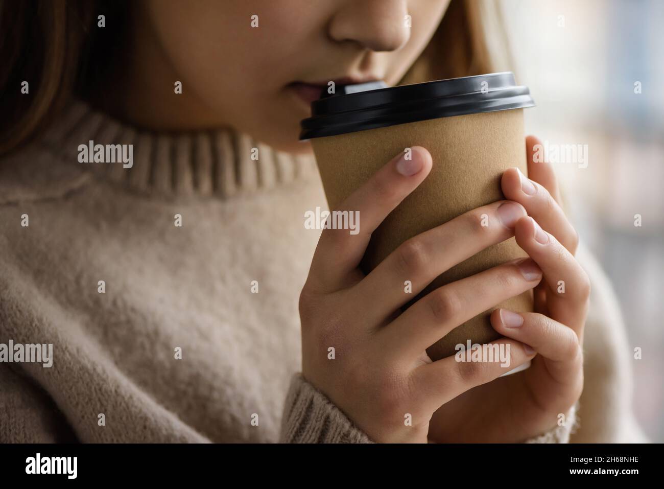 Girl is holding a paper cup with coffee. Stock Photo