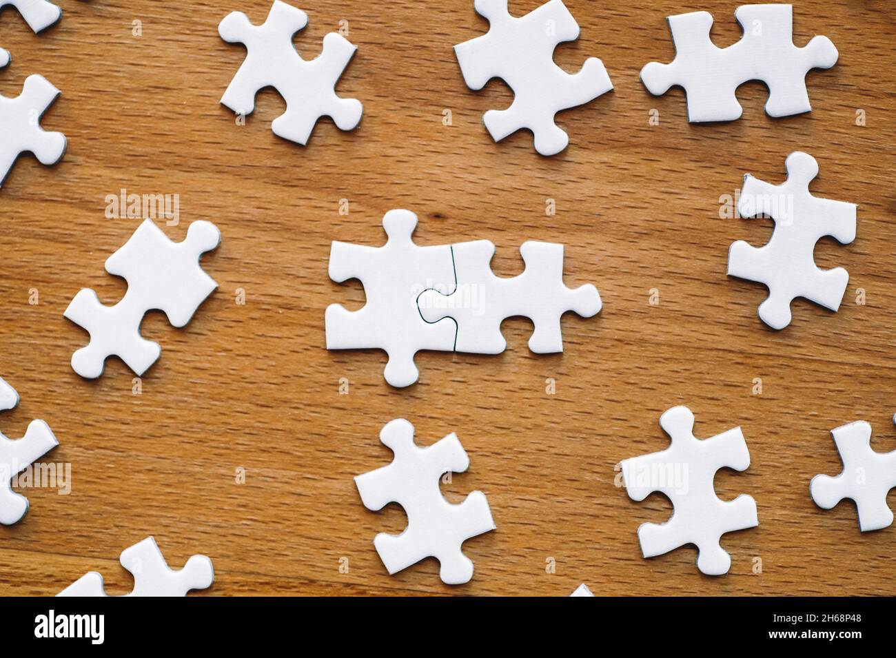 Puzzle pieces are connected. White puzzle pieces on a wooden table  background. Business, partner, solution, alliance, union concept. High  quality photo Stock Photo - Alamy