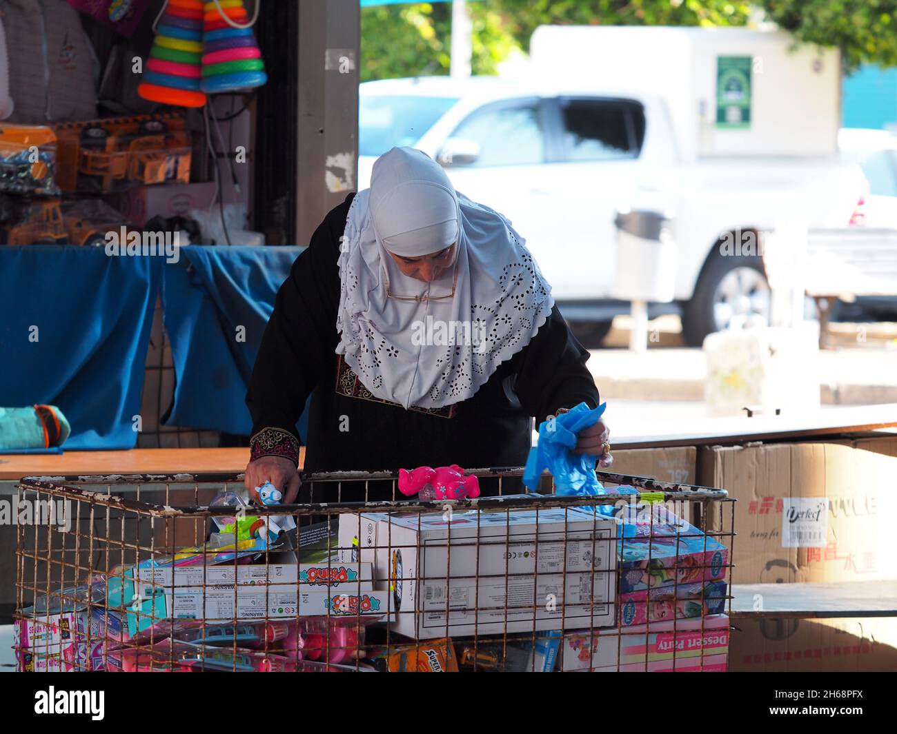 Arab woman chooses a toy for children in the Arab market. Stock Photo