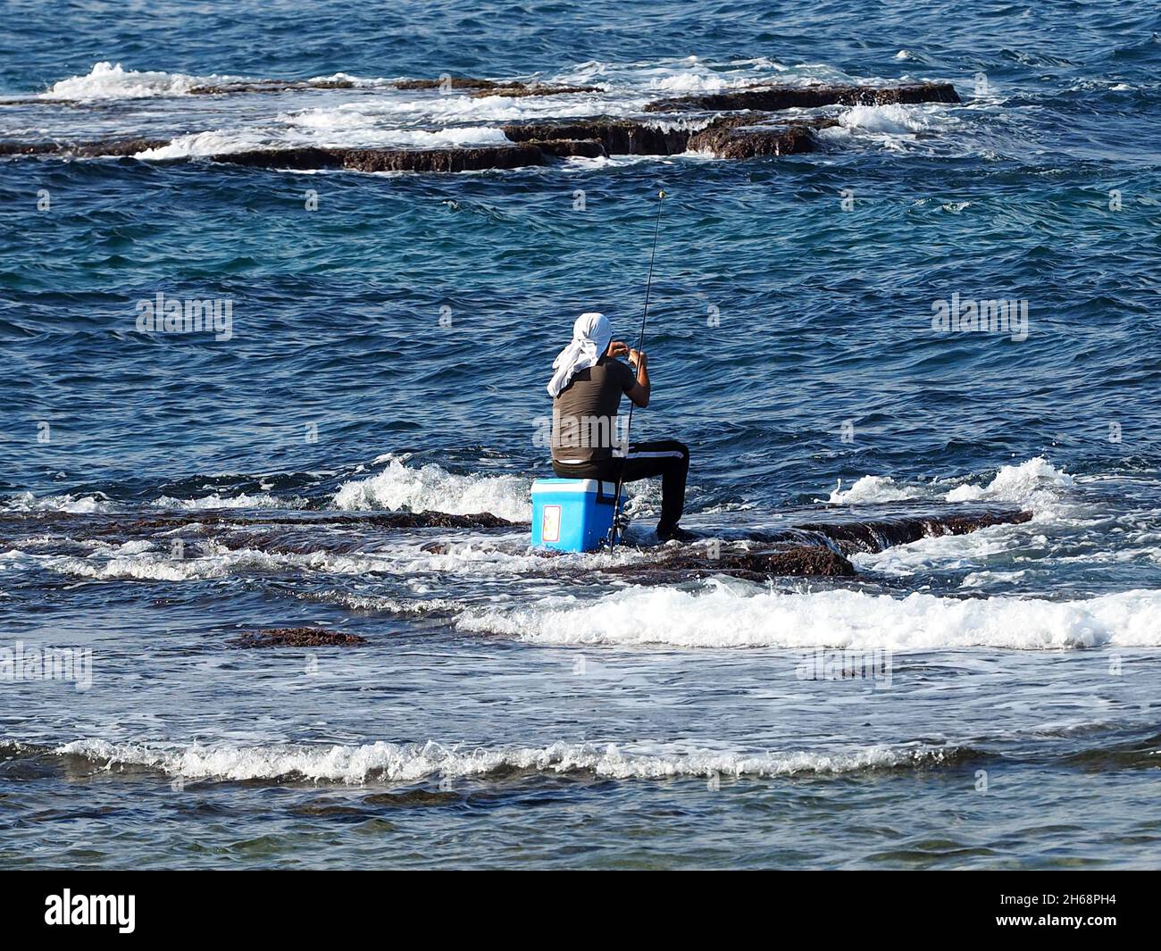 Man fishing in the mediterranean sea. Stock Photo