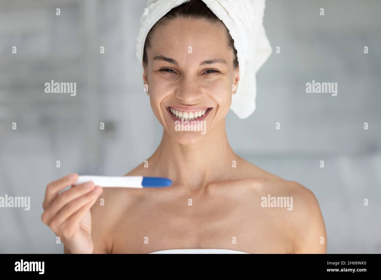 Joyful young latina hispanic woman holding pregnancy test. Stock Photo