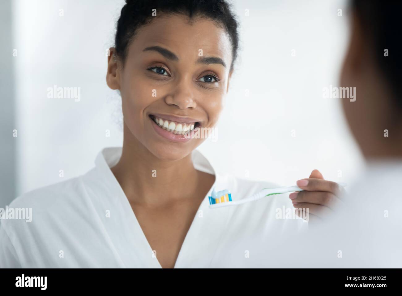 Young african american woman holding toothbrush with paste. Stock Photo
