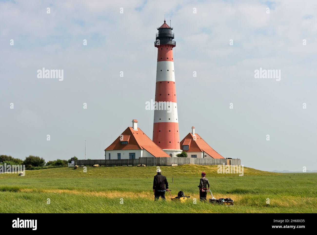 Hikers at the lighthouse Westerheversand,Westerhever, Eiderstedt peninsula, Schleswig-Holstein Wadden Sea National Park, Schleswig-Holstein, Germany Stock Photo