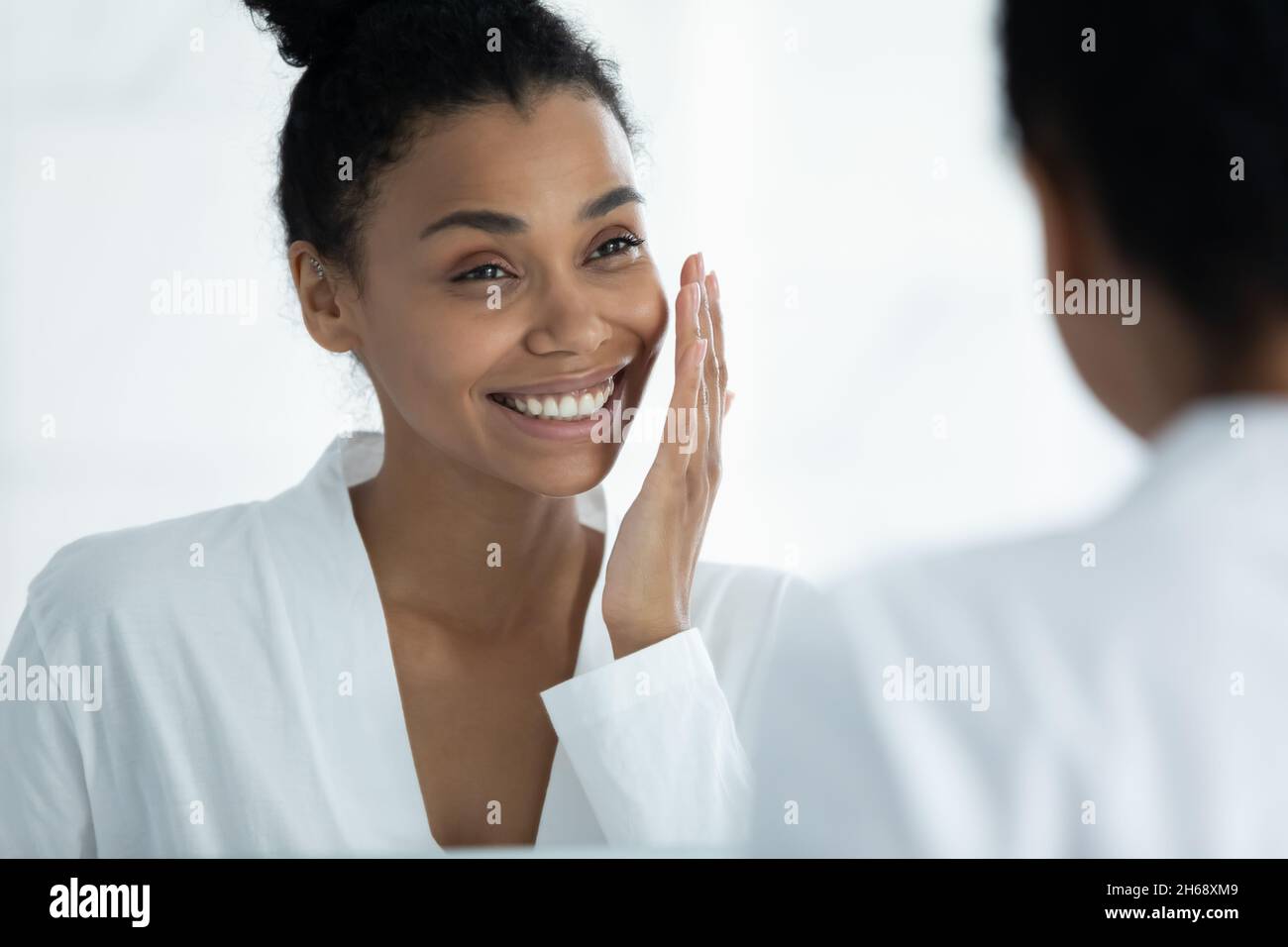 Happy young african american woman touching soft skin. Stock Photo