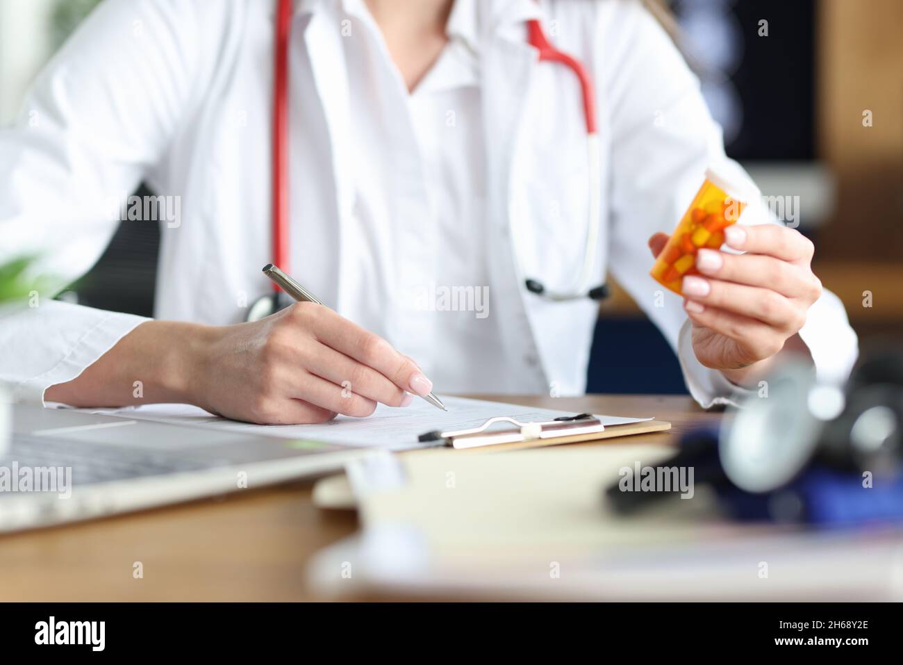 A woman doctor is holding a medicine makes notes in the documents Stock ...