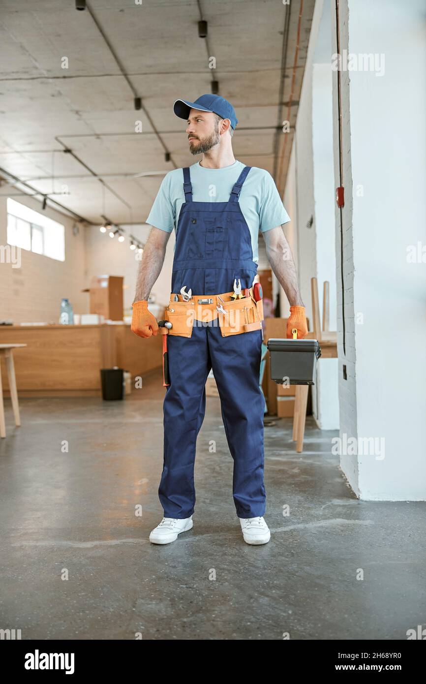Bearded male worker holding plastic box with tools Stock Photo