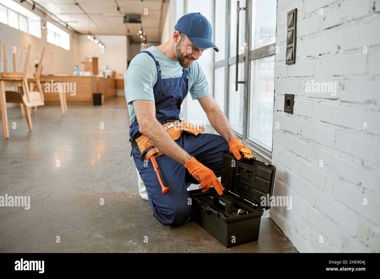Male electrician using tool box to repair electrical socket Stock Photo
