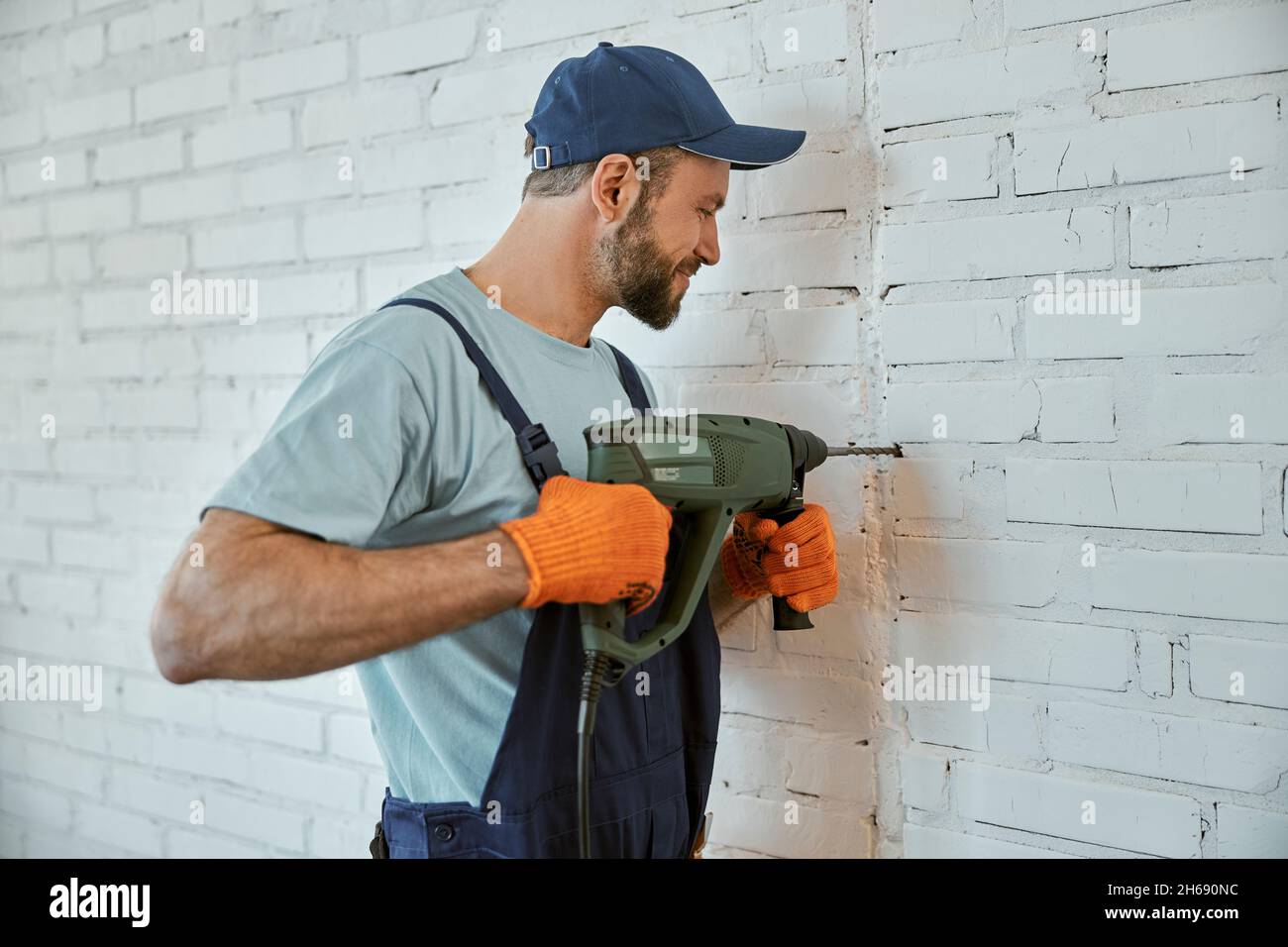 Male builder drilling wall with hammer drill Stock Photo Alamy
