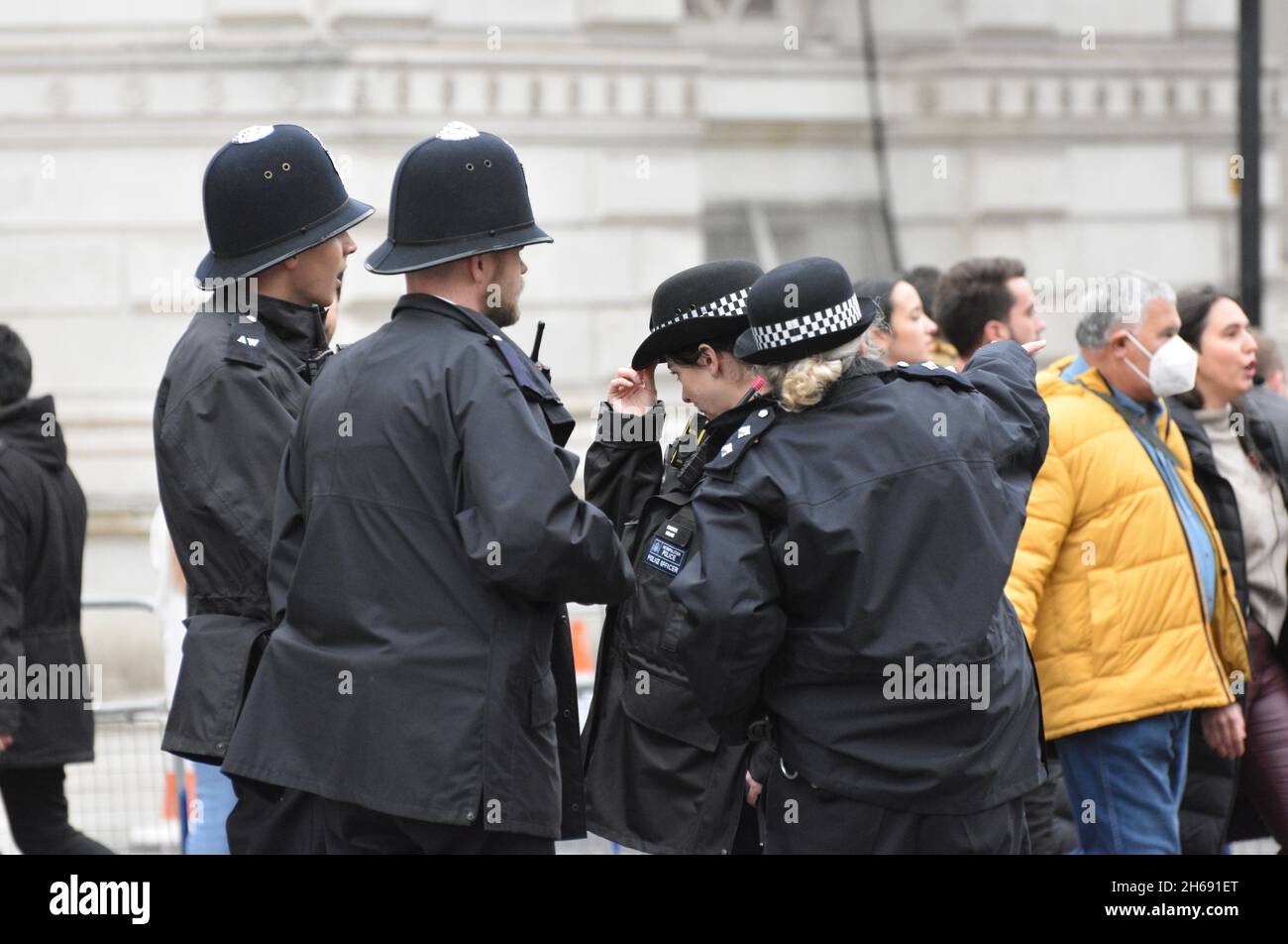 Four Metropolitan Uniformed Police Officers on duty in Westminster London. Two female and two male police officers stand together having a conversation. Stock Photo