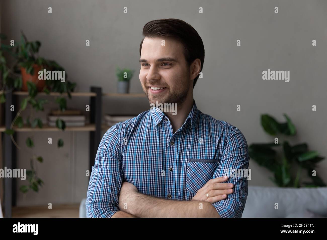 Head shot handsome young man standing with folded arms. Stock Photo