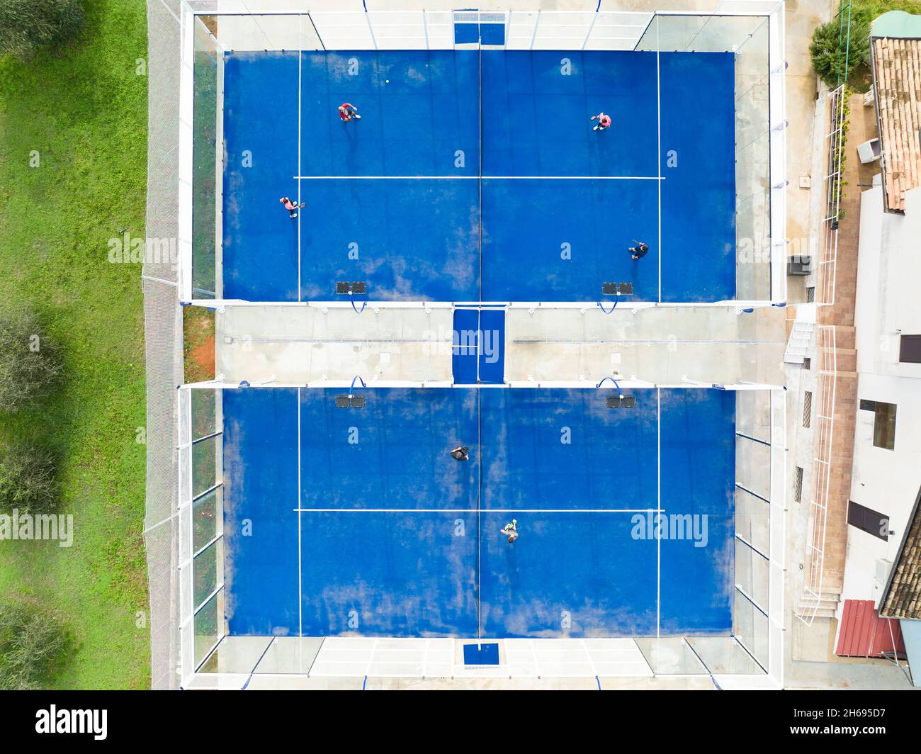 View from above, stunning aerial view of some people playing on a blue padel court. Padel is a mix between Tennis and Squash. Stock Photo
