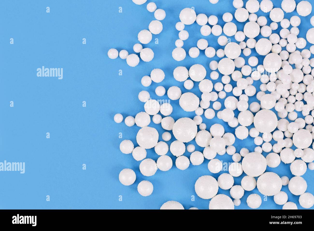 White round polystyrene snow balls on blue background with copy space Stock Photo