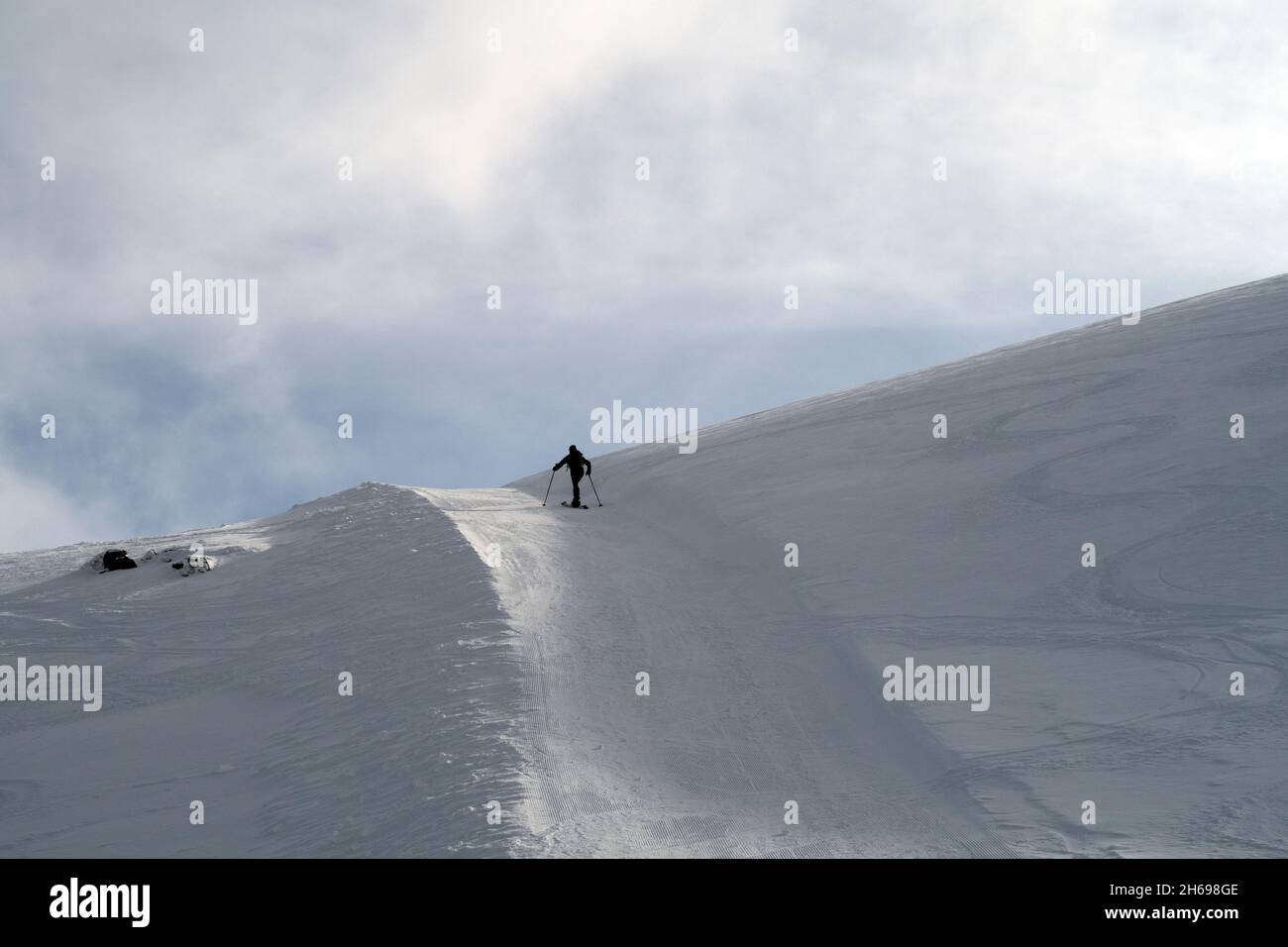 Uphill skier on sunny day Stock Photo