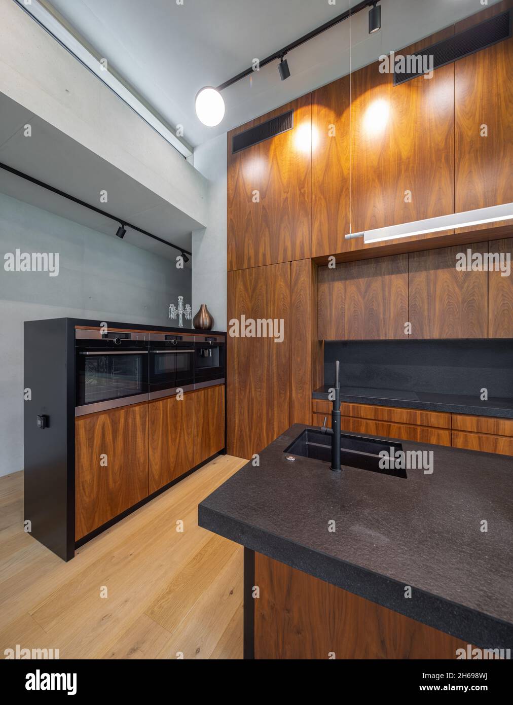 Modern interior of wooden kitchen with sink and black counter. Built-in ...